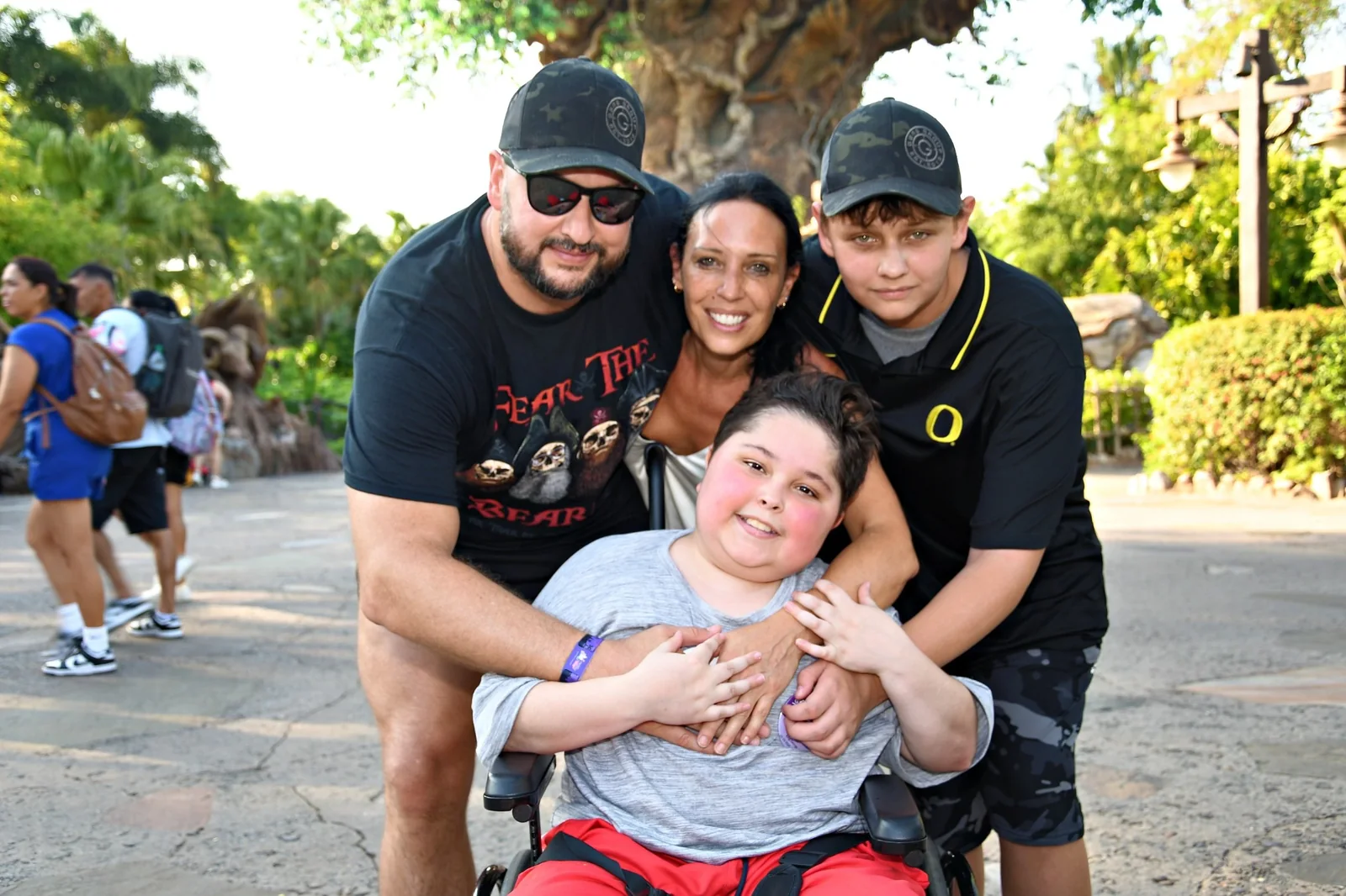 Jack smiling in his wheelchair with his family outdoors